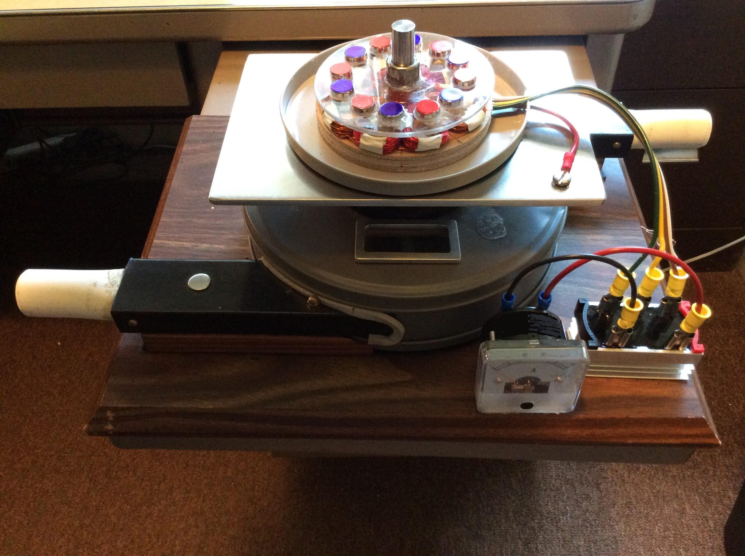 generator, is a disc-shaped, low-speed, axial-flux, iron-less, brushless, three phase AC machine. It has a multi-pole magnet rotor with a thin air gap between the magnets and copper stator windings. The output of the wye-wound stator windings is rectified to DC and the PM rotor is directly driven by the wave or tidal converter's driveline. No gearbox is required. The new generator design has minimal electrical and mechanical drag on the WEC's powertrain.